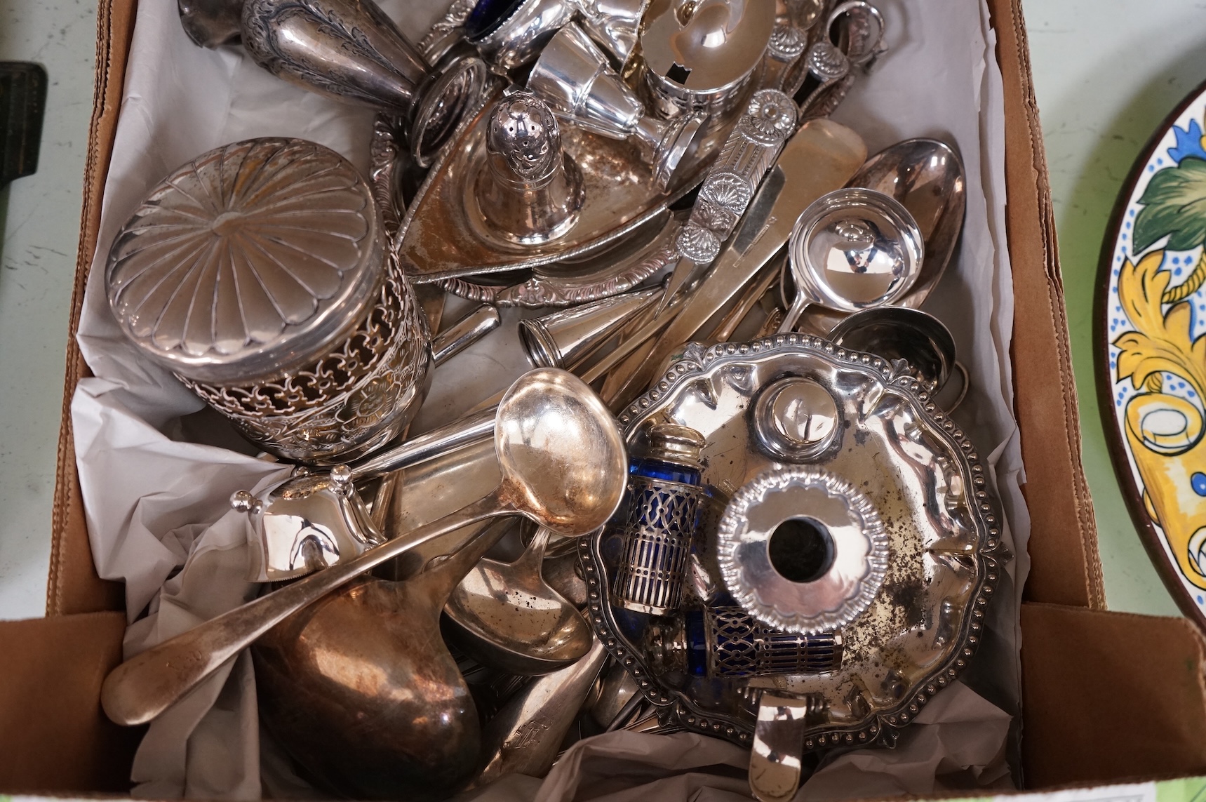 A collection of small plated wares including a pair of candle sticks, cruets, cutlery, sugar shaker, etc